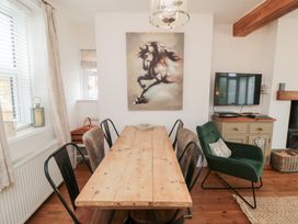 A dining room with a wooden table and chairs at Harriet's Cottage in Briggswath