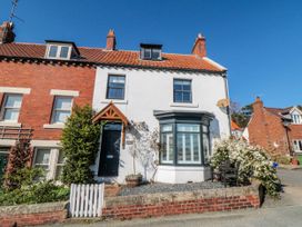 A house with a front door and windows at Harriet's Cottage in Briggswath