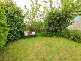 A garden with a bench among trees and bushes at Sea View in Benllech