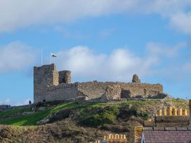 A castle in ruins on a hill with a flag at Dubrovnik