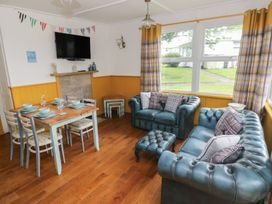 A living room with a sofa and dining area at Driftwood in Roch