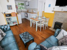 A living room with a dining area and kitchen at Driftwood in Roch