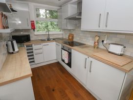 A kitchen with appliances and cabinets at Driftwood in Roch
