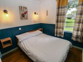A bedroom with a bed and wall lights at Driftwood in Roch