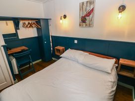 A bedroom with a bed and a chair at Driftwood in Roch