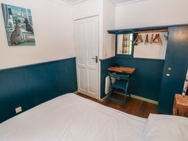 A bedroom with a bed, desk, and door at Driftwood in Roch