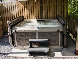A hot tub with steps on a gravel area at Reflection in Longtown