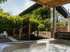 An outdoor area with a hot tub and seating at Reflection in Longtown