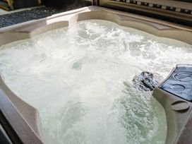 A hot tub filled with water in an outdoor area at Reflection in Longtown
