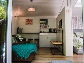 A living room with a sofa and kitchenette at Reflection in Longtown