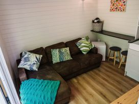 A living room with a brown sofa and a table at Reflection in Longtown