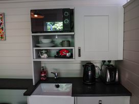 A kitchen with a microwave, kettle, and sink at Reflection in Longtown