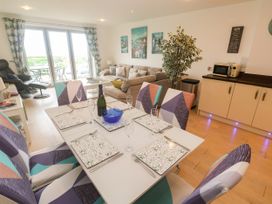 A living room and dining area with a table and chairs at Ocean Seven in Newquay