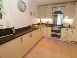 A kitchen with cabinets and appliances at Ocean Seven in Newquay