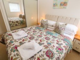 A bedroom with bed and mirror at Ocean Seven in Newquay