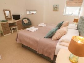 A bedroom with a bed, desk, chair, and lamp at Ocean Seven in Newquay