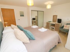 A bedroom with two beds and a desk at Ocean Seven in Newquay