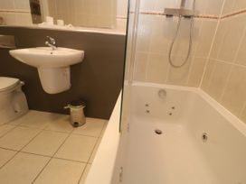 A bathroom with a bathtub, toilet, and sink at Ocean Seven in Newquay
