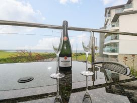 A bottle of champagne and glasses on a table with a view at Ocean Seven in Newquay