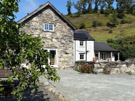 A stone house with solar panels and gravel driveway at Peniarth Ganol in Tywyn