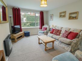 A living room with sofas and a television at Awelon in Rhos-On-Sea