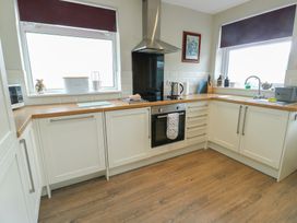 A kitchen with cabinets and appliances at Awelon in Rhos-On-Sea