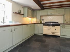 A kitchen with cabinets and stove at Plas Mawr in Groeslon