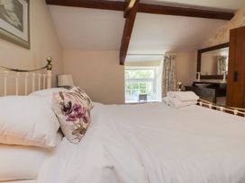 A bedroom with a bed and window at Plas Mawr in Groeslon