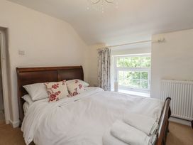 A bedroom with a bed and window at Plas Mawr in Groeslon