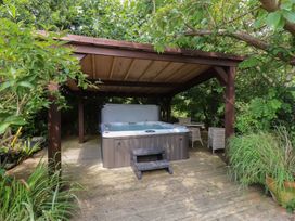 A garden with a hot tub and seating area at Plas Mawr in Groeslon