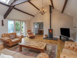 A living room with a fireplace and seating area at Beudy'r Wennol in Groeslon