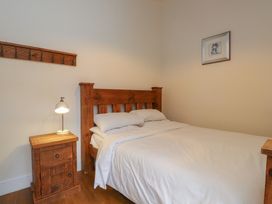 A bedroom with a bed and lamp at Beudy'r Wennol in Groeslon