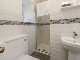 A bathroom with a shower, toilet, and sink at Beudy'r Wennol Groeslon