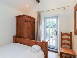 A bedroom with a bed and wardrobe at Beudy'r Wennol Groeslon