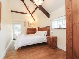 A bedroom with a bed and nightstand at Beudy'r Wennol in Groeslon
