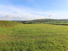A field with grass and hills in the background at Cherry Lodge in Lanivet near Bodmin