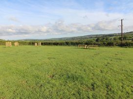 A grassy outdoor area with a viewing platform at Cedar Lodge in Lanivet near Bodmin