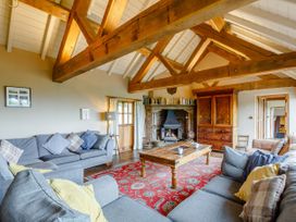 A living room with wooden beams and a fireplace at Pant Dafydd Goch in Llangollen