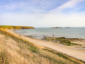 A sandy beach with rocky patches ocean and grassy cliffs Bryn Ffynnon Bryncroes near Aberdaron