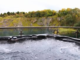 A hot tub with water overlooking a rocky cliff at Boavista in Carnforth