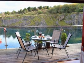 A balcony with a table and chairs overlooking a water body at Boavista in Carnforth