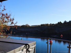 An outdoor view of a lake with cliffs and a hot tub at Boavista in Carnforth