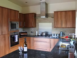 A kitchen with cabinets, countertop, stove, and appliances at Boavista in Carnforth