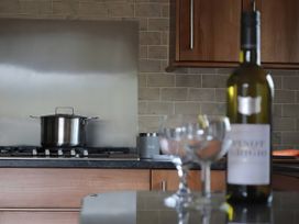 A kitchen with a pot on the stove and a wine bottle on the counter at Boavista in Carnforth