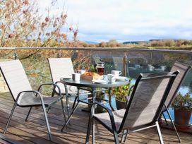 A deck with chairs and a table set for tea at Boavista in Carnforth