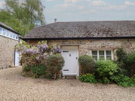 An exterior view of a cottage with a white door and plants at Pottery Barn in Branscombe