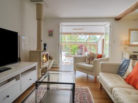 A living room with a wood stove and glass door to the garden at Pottery Barn in Branscombe