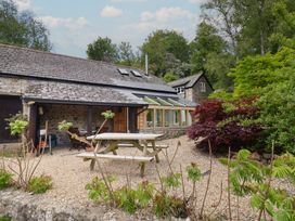 An outdoor area with a picnic table and garden at Pottery Barn in Branscombe