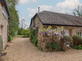 A stone cottage with a gravel path and flowers at Pottery Barn in Branscombe