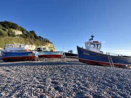 Three boats on a pebbly beach at Pottery Barn in Branscombe